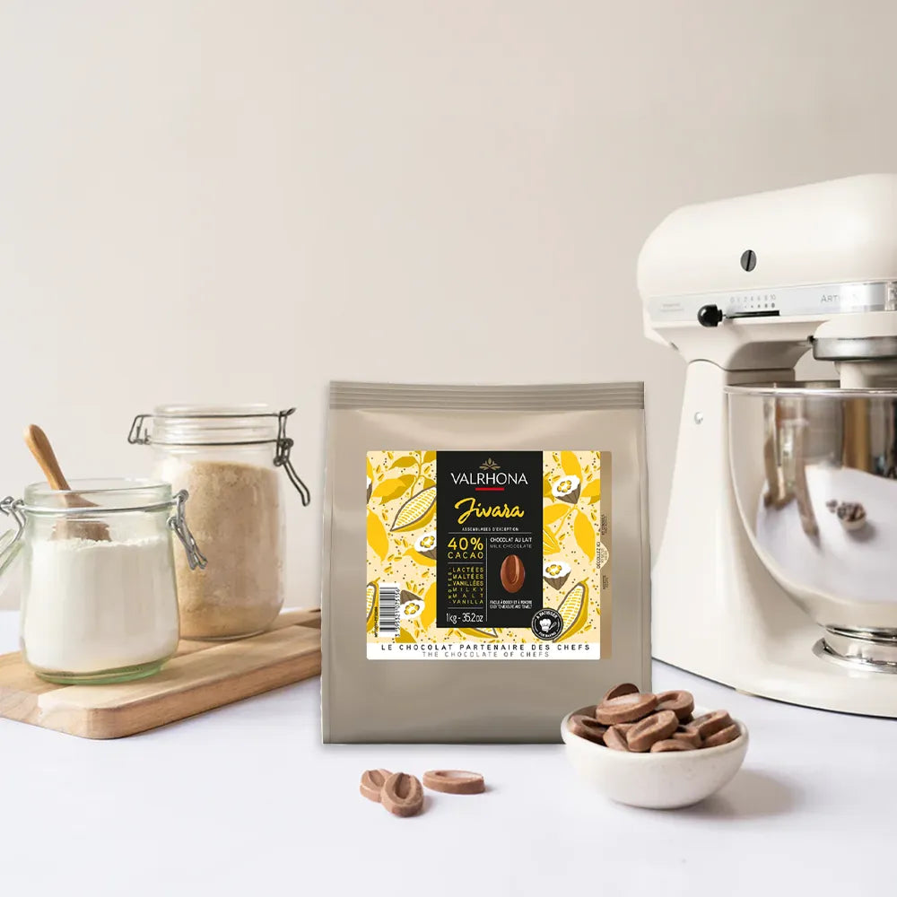 Sachet de fèves de chocolat au lait Jivara 40% de Valrhona pour la pâtisserie, format 1 kg, présenté sur fond clair.